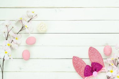 Tablo üstten görünüm süslemeleri mutlu Paskalya tatili arka plan kavramı bir kadeh. Düz bunny pembe çiçeği ve çeşitli dekor ile modern rustik Beyaz ahşap sezon için yumurtalarını. Boş alan Tasarım.