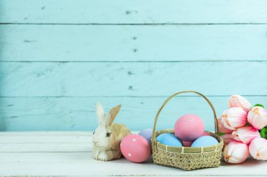 Dekorasyon mutlu Paskalya tatili arka plan kavramı bir kadeh. Düzenleme bunny yumurta ile Pembe Lale üzerinde beyaz ve mavi rustik ahşap evde Ofis Masası masa. Yaratıcı tasarım için negatif boşluk.