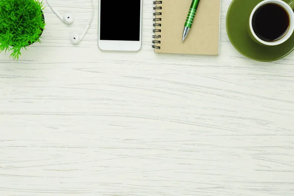 Table top view aerial image stationary on office desk background concept.Flat lay objects the black coffee with essential accessory & mobile phone.Items on modern white wooden at home studio.