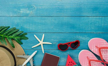 Kıyafet kadınların masa üstü görünüm aksesuar yaz tatili arka plan kavramı seyahat planlıyoruz. Modern rustik mavi ahşap üzerinde birçok temel öğeleri şapka ve güneş gözlüğü ile dondurma. Tasarım alanı.