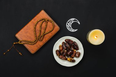 Masa üstü görünüm dekorasyon Ramazan Kareem tatil arka plan havadan görüntü. Tespih ve aydınlatma ile düz yatıyordu tarih. Ofis masasında modern rustik siyah ahşap Müslüman Temel nesne kutsal Kur'an.