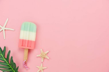 Giyim kadınların Masa üstü görünüm aksesuar yaz tatili arka plan konsepti seyahat planlıyoruz. Modern rustik pembe kağıt üzerinde birçok temel öğeleri yaprak ve denizyıldızı ile dondurma. Tasarım için kopyalama alanı.