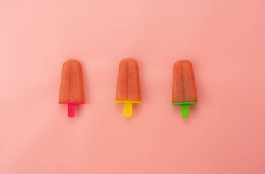 Yaz tatili arka plan konsepti için gıda tablo üst görünümü havadan görüntü. Düz modern rustik pembe kağıt duvar kağıdı üzerinde ev yapımı tarafından karpuz dondurma pop sopa yatıyordu. Minimal stil pastel ile desen.