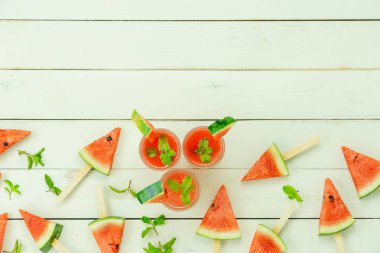 İlkbahar yaz tatili ve tatil arka plan konsepti ile içecek ile masa üstü görünümü meyve tropikal. Düzenleme dilimleri modern beyaz ahşap karpuz dondurma deseni. Tasarım metni için alan kopyalama.