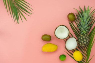 Bahar yaz tatil ve tatil arka plan kavramı ile tablo üst görünüm meyve tropikal. Aranjman palmiye yeşili yaprakları çeşitli ananas Mango limon ve kireç dilimlenmiş. Pembe kağıt üzerinde öğeler. pastel.