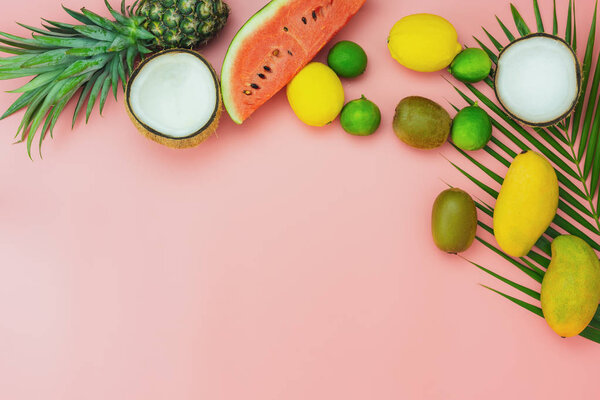 Table top view fruit tropical with spring summer holiday & vacation  background concept.flat lay arrangement sliced various watermelon pineapple kiwi mango lemon and lime coconut on pink paper.
