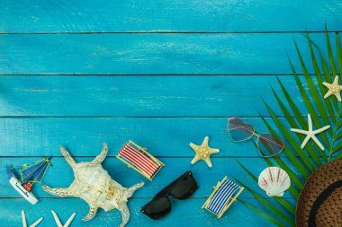 Masa üstü görünüm giyim kadın ve erkek aksesuar yaz tatili arka plan konsept.hat birçok temel öğeleri güneş gözlüğü ve modern rustik mavi ahşap şapka ile seyahat planlıyoruz. Tasarım alanı.