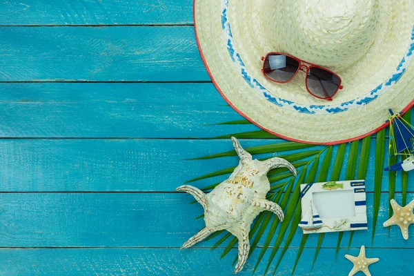 Table top view accessory of clothing women & men  plan to travel in summer holiday background concept.hat with many essential items sunglasses & hat on modern rustic blue wooden.Space for design.