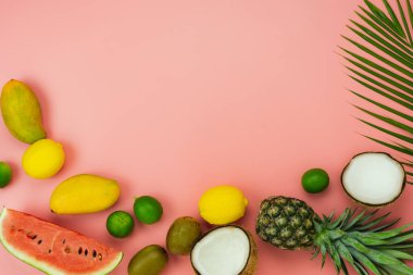 Bahar yaz tatil ve tatil arka plan kavramı ile tablo üst görünüm meyve tropikal. Aranjman palmiye yeşili yaprakları çeşitli ananas Mango limon ve kireç dilimlenmiş. Pembe kağıt üzerinde öğeler. pastel.