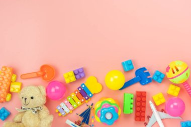 Arka plan konsepti geliştirmek için masa üstü görünüm dekorasyon çocuk oyuncakları. Düz yatıyordu aksesuarları bebek ofis masasında modern pembe kağıt üzerinde öğeleri çocuk ile oynamak için. Metin eklemek için yer kopyala.pastel ton duvar kağıdı.
