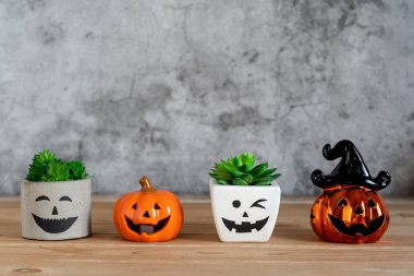 Dekorasyon aksesuarları Mutlu Cadılar Bayramı arka plan kavramı. Ürkütücü balkabaklarıyla Jack O Lantern kaktüsü modern rustik kahverengi ve beyaz taş fon üzerinde örümceklerle parti sezonuna karşı çıkıyor..