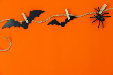 Masa üstü görüntü dekorasyonları Mutlu Cadılar Bayramı arkaplan tatil kavramı. Düz, parti balkabaklarına nesneler yerleştirdi. Örümcek ve yarasa tahta raptiyelere asılı turuncu duvar kağıtları üzerinde. Tasarım için alan kopyala