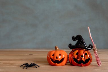 Dekorasyon aksesuarları Mutlu Cadılar Bayramı arka plan kavramı. Cadı süpürgesi ile ürkütücü balkabakları olan birkaç Jack O Fenerleri modern kahverengi ve beyaz taş zemin üzerinde parti sezonuna itiraz ediyor..