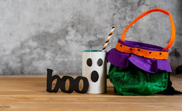 Accessories of decorations Happy Halloween sale day background concept.Cup of drink with pumpkin bag object to party season with spider on  brown & white backdrop at home office desk studio.copy space