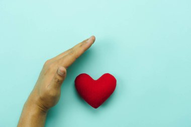 Ellerin mavi kağıtta kırmızı kalbin havadan görünüşü. Sağlık ve sağlık hizmetleri ve sevgililer günü arkaplanı kavramı. Güvenlik ve sigorta, uluslararası organ bağışı. Dünya Sağlık Günü.