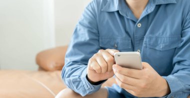 Genç adam cep telefonu cihazını tutuyor..