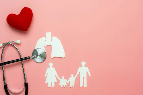 Aksesuarların hava görüntüsü. Ulusal Organ Bağış Günü 'nün sağlık sigortası ve Sevgililer Günü arkaplan kavramı. Stetoskop kırmızı kalp ailesi ve pembe kağıt üzerinde akciğeri. Kopya alanı