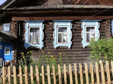 Dekoratif ahşap kulübe Windows çevresinde trim oyma / dekoratif tasarım penceresinin ek yük şeklinde açılış profilli şeritler şeklinde. İşlevsel olarak, kasa duvar ve pencere veya kapı çerçeve arasındaki boşluğu kapsar