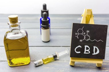Cam şişede CBD yağı ve molekül çizim ile kara tahta 