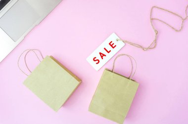 Pembe arka planda küçük alışveriş torbaları ile satış etiketi, online sho