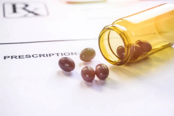 Spilled Cannabis oil capsules on doctor prescription paper