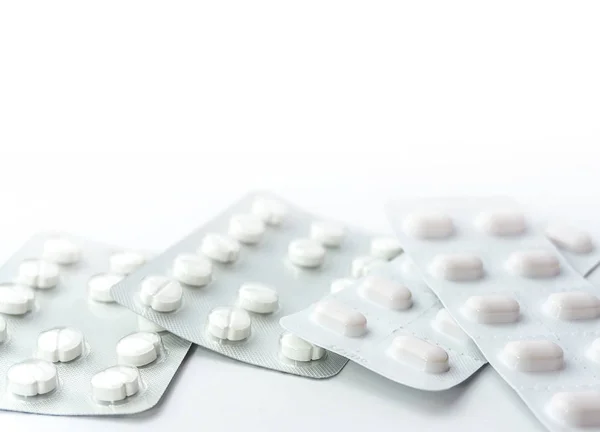 Pilules médicales en plaquettes thermoformées argent isolées sur fond blanc — Photo
