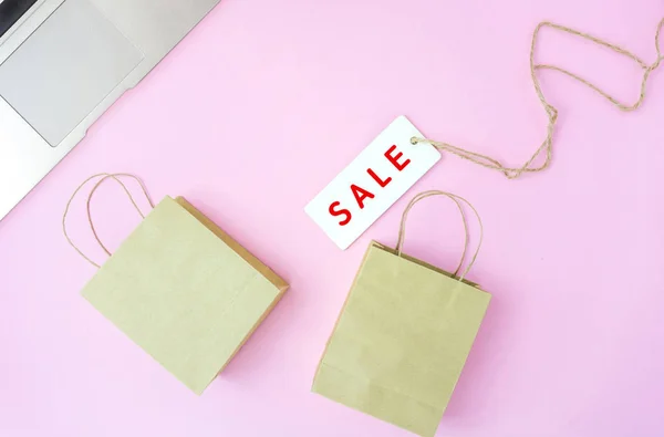 Sprzedaż tag z małymi torby na zakupy na różowym tle, online SHO — Zdjęcie stockowe