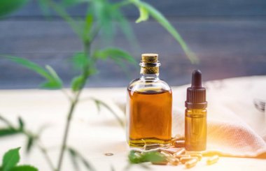 Ahşap masa üzerinde Açık Cbd Cannabidiol kapsül ve kenevir yağı