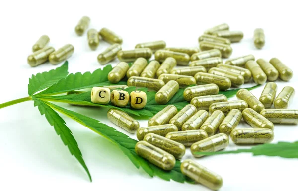 Des pilules CBD. Groupe de capsules claires de CBD Cannabidiol et feuille de chanvre isolées — Photo