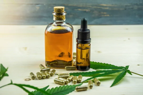Klare Cbd-Cannabidiol-Kapseln und Cannabisöl auf Holztisch — Stockfoto