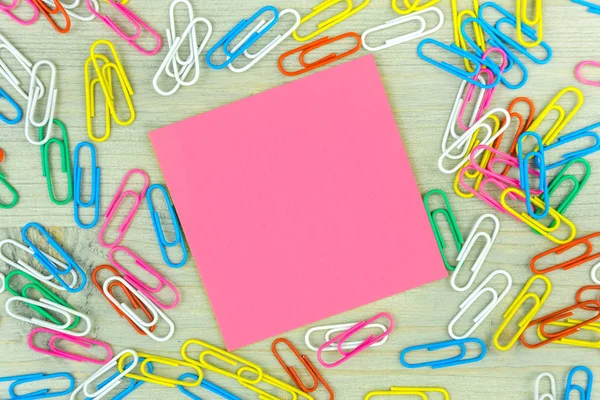 Różowe notatki z zestawem kolorowych spinki do papieru na drewnianym tle. koncepcje kreatywności w biznesie — Zdjęcie stockowe