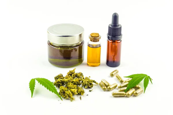 Frascos de vidrio de aceite de cannabidiol CBD, pastillas, capullos florales y hojas de cannabis aisladas — Foto de Stock