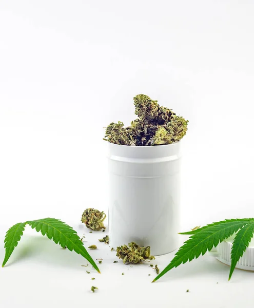 Recipiente blanco con capullos de flores de cannabis y hojas de cannabis aisladas en el concepto de marihuana blanca y medicinal — Foto de Stock