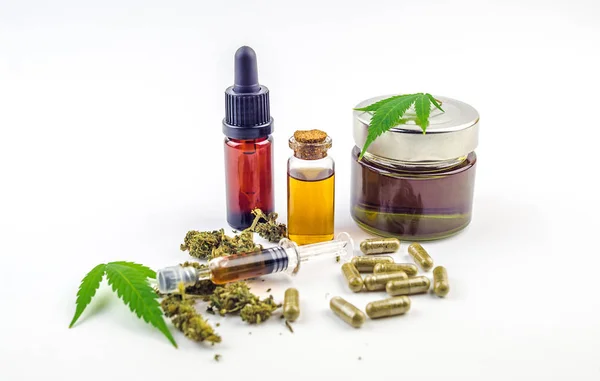 Frascos de vidrio de aceite de cannabidiol CBD, pastillas, capullos florales y hojas de cannabis aisladas — Foto de Stock