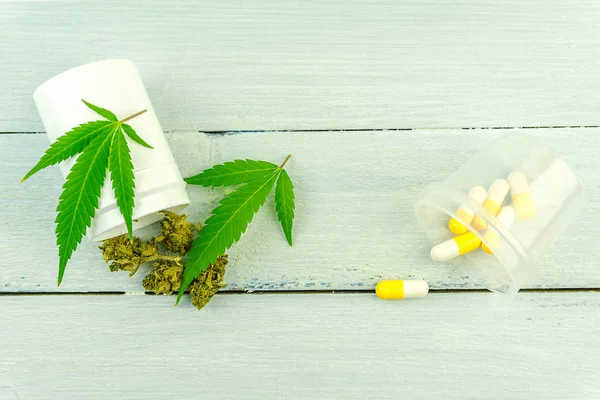 Cannabis brotes de flores hojas y píldoras recetadas en la mesa de madera, marihuana medicinal vs prescripción concepto de medicina — Foto de Stock