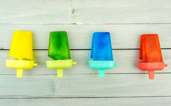 Kolorowe popsicles na jasnym niebieskim drewnianym stole, lato żywności — Zdjęcie stockowe