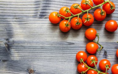 Siyah rustik ahşap masa üzerinde bir dal üzerinde Kiraz domates