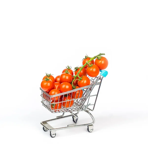 Carrito de compras en miniatura lleno de pequeños tomates cherry aislados —  Fotos de Stock