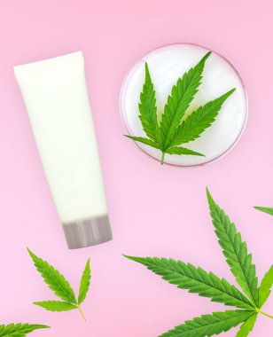 CbD losyon jelleri ve pembe arka plan üzerinde izole Esrar yapraklar