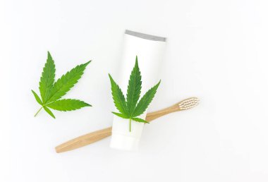 Cannabis CBD toothpaste with Cannabis leafs and wooden toothbrush clipart