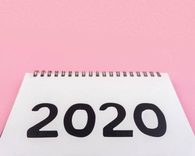 Yeni yıl 2020 kavramı: masaüstü takvim düz yatıyordu pembe izole