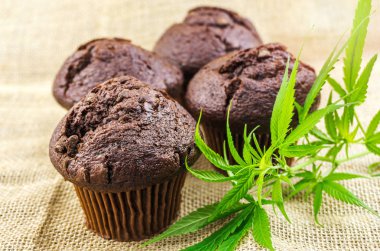 Cannabis cupcake muffins and Hemp leaves on hemp burlap clipart