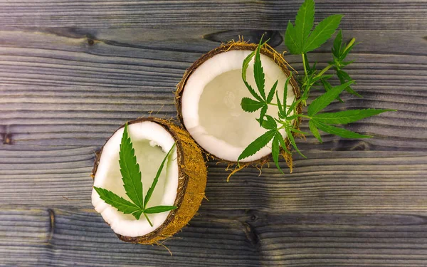Vue du dessus des feuilles de noix de coco et de cannabis sur une table en bois — Photo