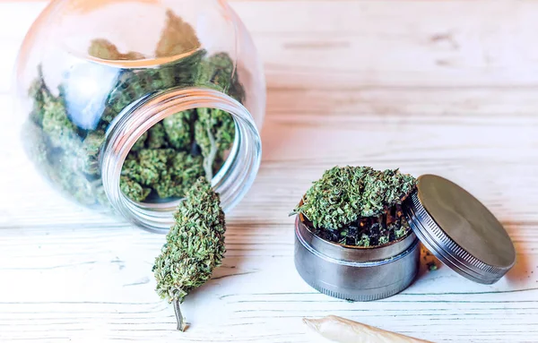 Tunas Bunga Cannabis Dalam Botol Kaca Dan Penggiling Atas Meja — Stok Foto