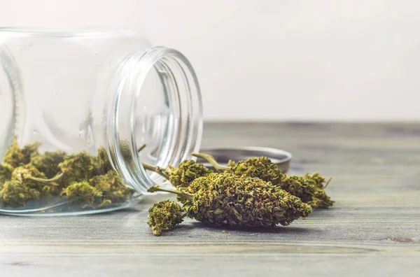 Marijuana Medis Dalam Botol Kaca Atas Meja Terhadap Latar Belakang — Stok Foto