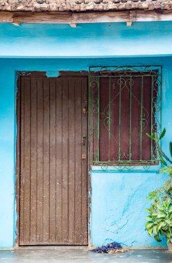 Trinidaad, Küba 26 Kasım 2017 - kahverengi kapı ve rendelenmiş pencere mavi duvar