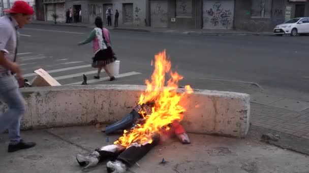 Cuenca, Ecuador - 31 de diciembre de 2018 - La familia quema efigie representando lo malo del Año Viejo cuando pasan automóviles y peatones — Vídeos de Stock