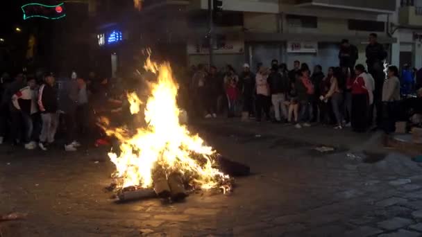 Cuenca, Ecuador - December 31, 2018 - People dance in circle next to street bonfire at midnight on New Year Eve — стоковое видео