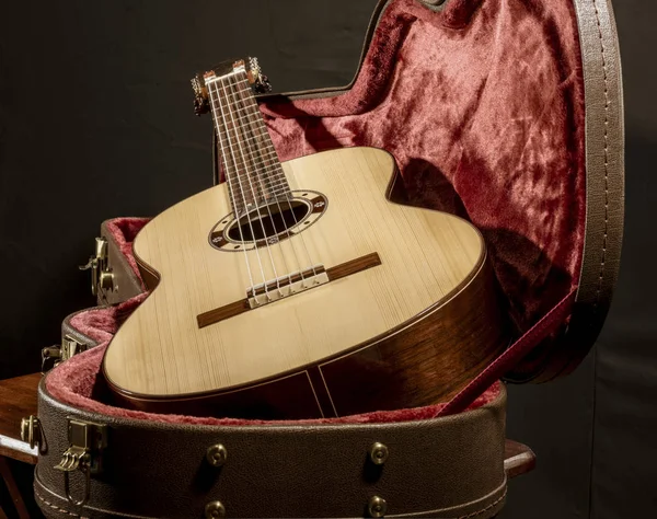 Guitarra acústica senta-se em caixa forrada de veludo vermelho — Fotografia de Stock