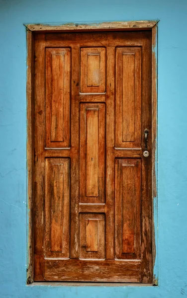 La Entrade, Ecuador - September 14, 2018 - oranje deur op blauwe muur. — Stockfoto